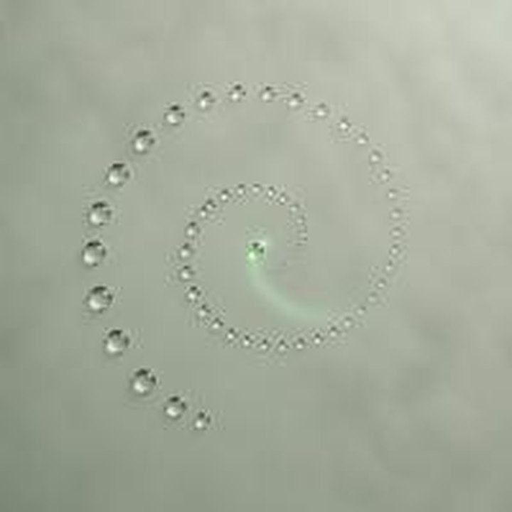 Spiral of glass droplets with one jade droplet returning to the center